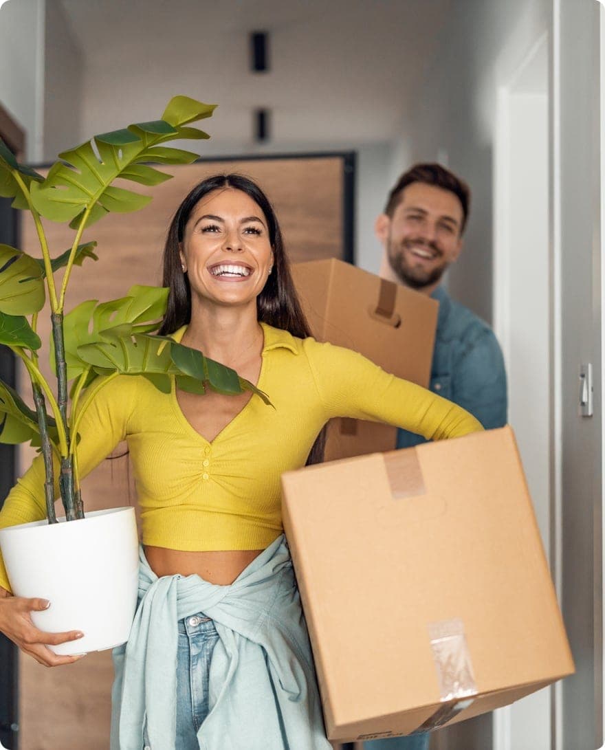 Couple carrying boxes into their first home