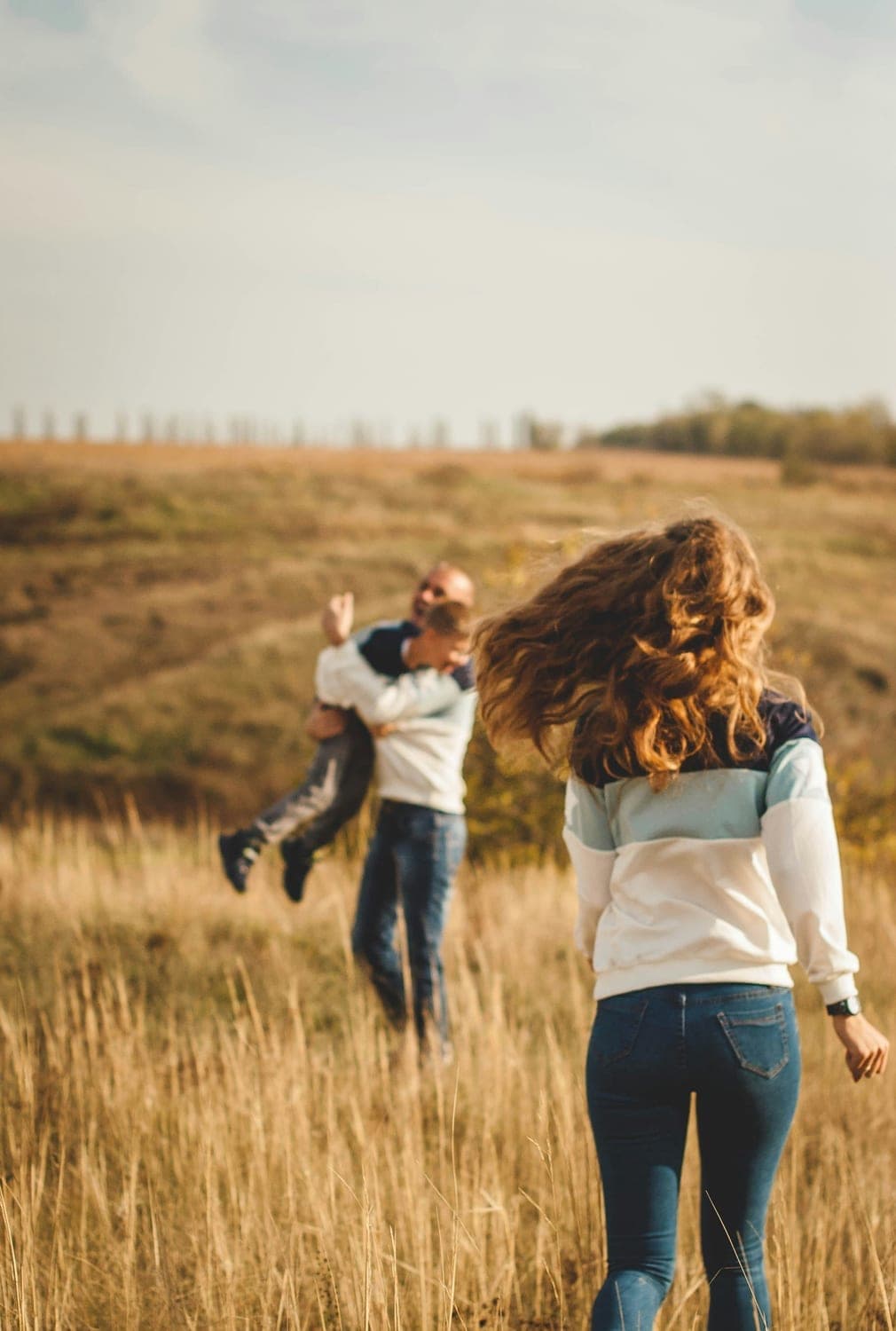 Family walking through golden fields towards the future