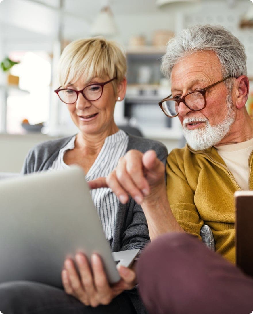 Retired couple reviewing their finances together on a laptop