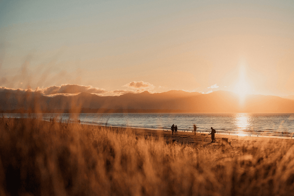 Beach at sunset with group of people in distance