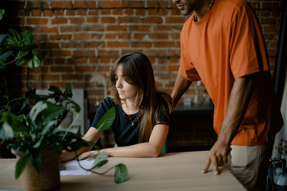 Couple looking at laptop in front of brick wall